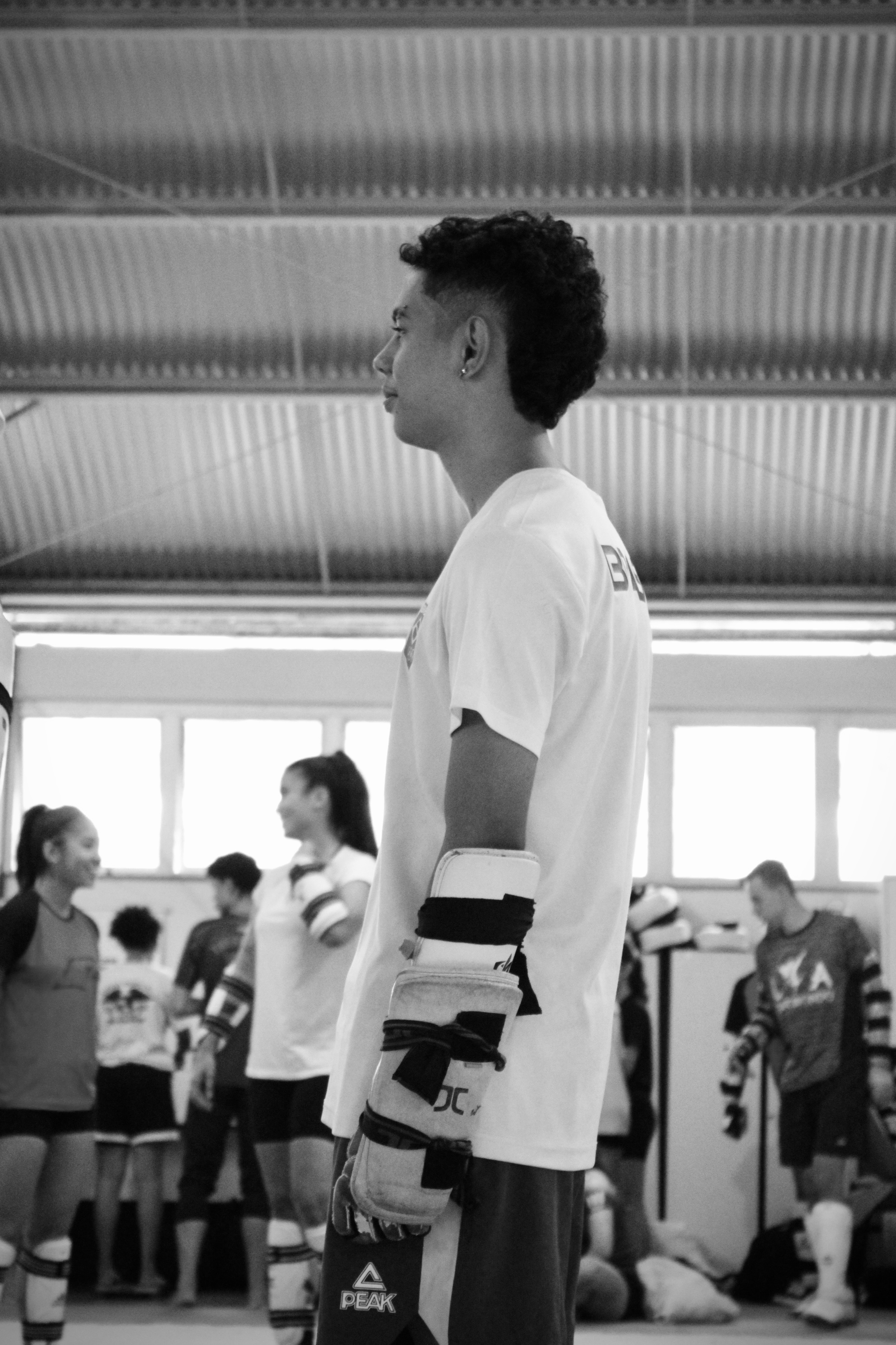 Retrato em preto e branco de atleta juvenil com equipamento completo de kyorugui, em instante de concentração antes do combate.